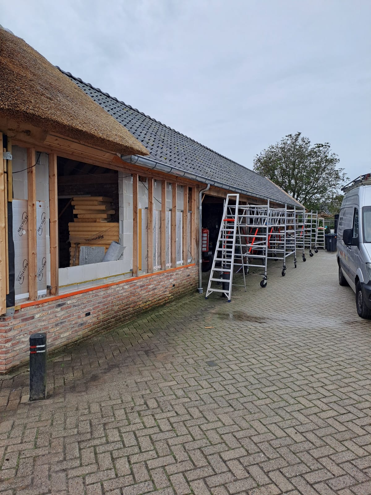 Pand in renovatie met steiger en rieten dak