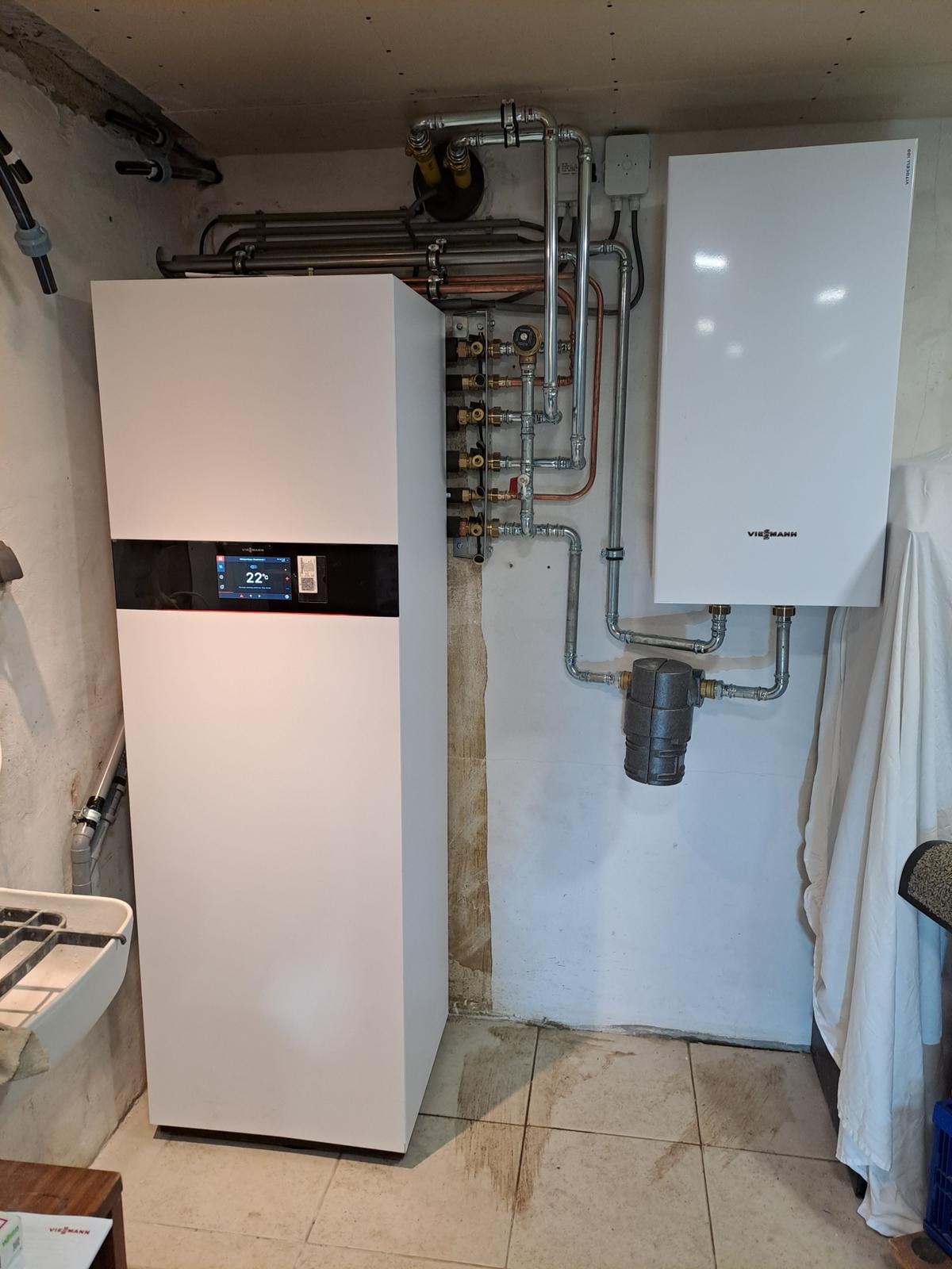 Buitenunit van een warmtepomp naast een woning
